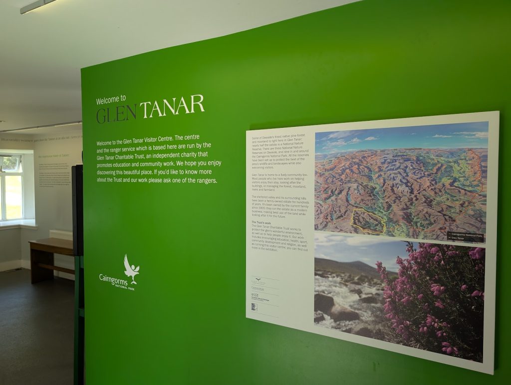 Inside a building with a big green wall and the text "Welcome to Glen Tanar". 